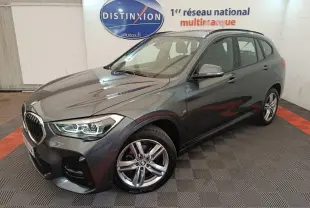 BMW X1 sDrive18i M Sport gris métallisé vue 3/4 avant droit en intérieur showroom avec jantes alliage cinq branches