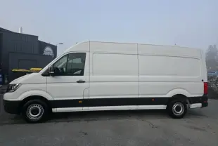 Vue de profil côté gauche d'un Volkswagen Crafter Fourgon blanc avec bas de caisse noir et jantes acier argentées.