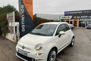 Vue 3/4 avant d'une FIAT 500 blanche de 2019, essence, garée devant un concessionnaire Distinxion.