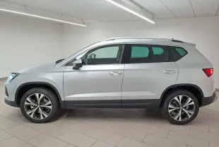 Vue de profil droit du SUV SEAT Ateca 2025 en argent métallisé avec jantes alliage 18 pouces dans un intérieur neutre.