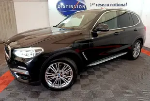 BMW X3 xDrive20d noir en 3/4 avant droit, avec jantes alliage et phares LED allumés dans showroom