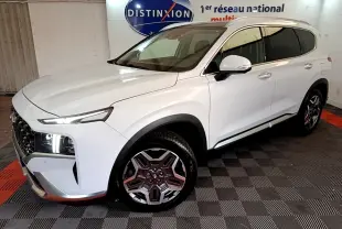 Vue 3/4 avant droit du Hyundai Santa Fe blanc avec phares LED allumés et jantes alliage distinctives.