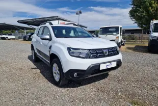 Dacia Duster blanc vue 3/4 avant droit, avec calandre noire et protections noires sur les bas de caisse.