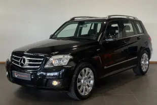 Mercedes GLK 220 CDI noir en 3/4 avant droit, avec jantes alliage et toit ouvrant visible en intérieur showroom.