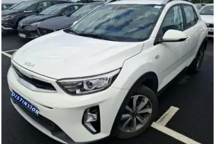 Vue 3/4 avant droite d’un KIA Stonic blanc 2023 avec détails noirs sur les passages de roues et calandre.