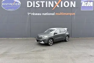 SUV Citroën C3 hybride gris foncé avec toit blanc, vu en 3/4 avant droit sous la pluie devant un mur gris.