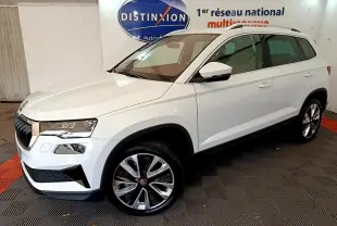 SKODA KAROQ blanc en 3/4 avant droit, avec jantes alliage et barres de toit chromées visibles