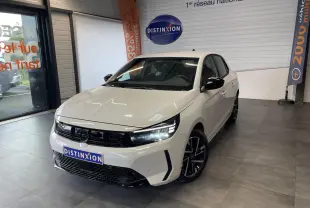 Opel Corsa blanche vue 3/4 avant droit en showroom, avec calandre noire et jantes alliage noires diamantées.