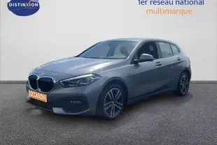 BMW Série 1 116i 2022 gris Frozen Pure Grey en 3/4 avant droit avec jantes bi-ton et calandre noire.