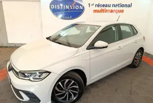 Vue 3/4 avant droite d'une Volkswagen Polo blanche avec jantes alliage noires et détails chromés dans un showroom.