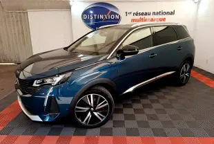 Peugeot 5008 bleu en 3/4 avant droit, jantes alliage noires et chrome, stationné en intérieur showroom