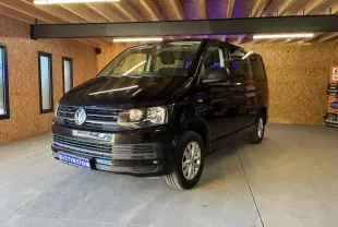 Volkswagen Multivan T6 noir vu en 3/4 avant droit dans un garage avec éclairage intérieur chaud.