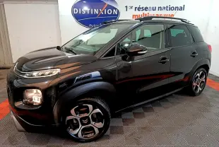 Citroën C3 Aircross noir vue 3/4 avant droit en intérieur, avec jantes distinctives et barres de toit noires.