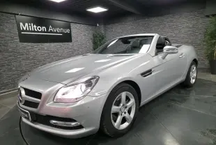 Mercedes SLK 200 BlueEfficiency gris métallisé vue 3/4 avant droit avec phares allumés et capote ouverte