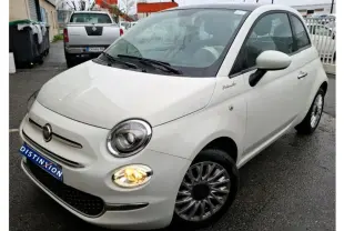 Vue 3/4 avant droite d'une Fiat 500 blanche Bossa Nova avec feux allumés et logo Dolcevita sur l'aile avant.