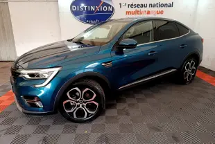 Renault Arkana Techno bleu en vue 3/4 avant droit, avec jantes distinctives et toit noir dans un showroom intérieur.