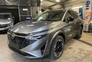 Vue 3/4 avant du Nissan Qashqai 1.5 E-POWER 205CH N-CONNECTA gris squale métal avec calandre noire et jantes noires.