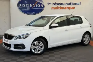 Peugeot 308 blanche vue de profil droit en intérieur, avec jantes alliage et calandre noire distinctive.