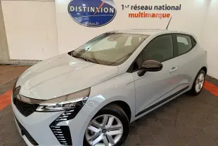 Renault Clio gris clair vue 3/4 avant droit en intérieur avec feux LED et jantes alliage visibles.