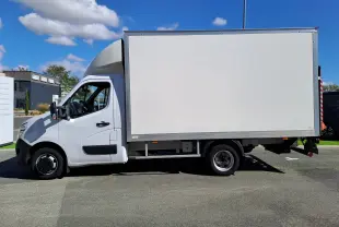 Vue latérale gauche d'un utilitaire blanc Nissan Interstar Chassis Cabine L3H1 2024 avec caisse fermée sur fond urbain.