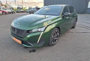 Peugeot 308 vert olivine vue 3/4 avant droit, avec calandre noire et feux LED verticaux distinctifs.