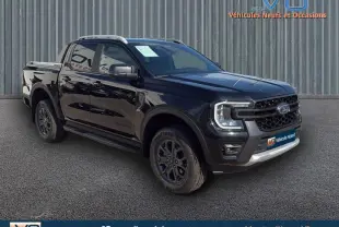 Ford Ranger Wildtrak noir en 3/4 avant droit, avec barres de toit, marchepieds et jantes alliage 18 pouces.