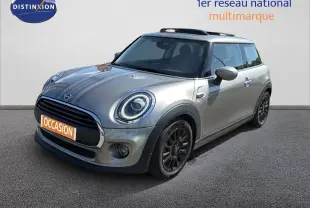 Vue 3/4 avant droite d'une MINI One beige avec jantes noires et bandes décoratives sur le capot.