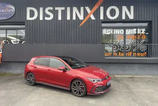 Volkswagen Golf 8 GTI rouge vue 3/4 avant droit, avec jantes sport et toit noir brillant.
