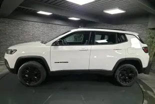 Jeep Compass blanc vu de profil côté gauche, avec jantes noires et détails noirs contrastants.