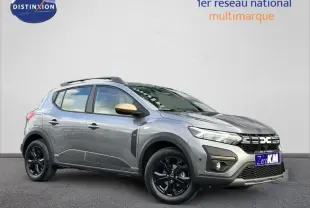 Dacia Sandero Stepway 2025 gris schiste métallisé en 3/4 avant droit avec jantes noires et coques de rétroviseur bronze.