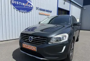 Volvo XC60 gris foncé en 3/4 avant droit, avec calandre distinctive et plaque orange "OCCASION" visible.