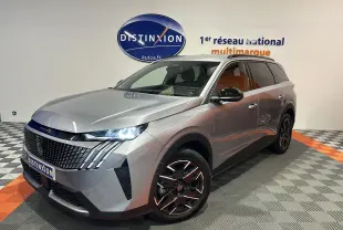 Peugeot 5008 gris Artense en 3/4 avant droit, avec phares LED allumés et jantes noires brillantes.