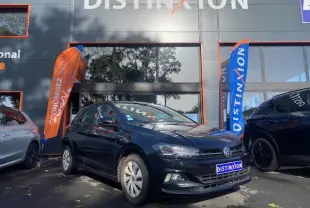 Volkswagen Polo noire vue en 3/4 avant droit devant un showroom avec drapeaux orange et bleu Distinxion.