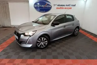 Peugeot 208 gris clair vue 3/4 avant droit, avec feux LED allumés et rétroviseurs noirs contrastants.