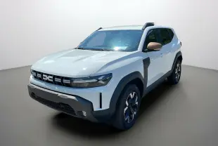 Dacia Duster blanc en 3/4 avant droit avec rétroviseurs couleur bronze et protections noires marquées.