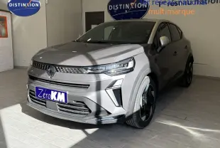 Vue 3/4 avant d'un Renault Captur 2025 gris Cassiopée métal avec toit gris, en showroom intérieur.