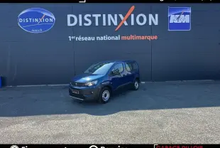 Peugeot Rifter bleu 2024 en 3/4 avant droit, version 1.5 BlueHDi 100 S&S Taille M Allure, stationné devant un mur gris.