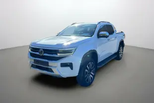 Volkswagen Amarok Simple Cabine blanc en 3/4 avant droit, avec jantes alliage et barres de toit visibles.