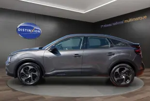 Profil droit d'une Citroën C4 gris foncé 2023 avec jantes noires et détails noirs contrastants.