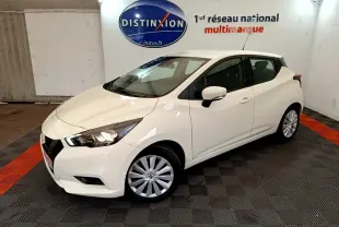 Nissan Micra IG-T 92 Acenta blanche vue 3/4 avant droit dans un showroom avec logo Distinxion en arrière-plan.