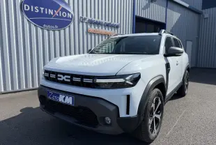 Vue 3/4 avant droit du Dacia Duster Hybrid 155 Journey blanc glacier avec calandre noire et jantes noires.