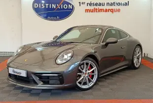 Porsche 911 Carrera 4S Coupé gris foncé vue 3/4 avant droit, jantes argent et étriers rouges visibles
