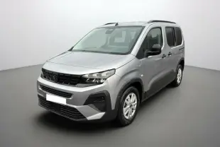 Peugeot Rifter gris artense en 3/4 avant droit, avec barres de toit et vitres arrière surteintées.