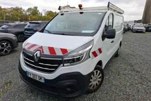 Renault Trafic Fourgon blanc en 3/4 avant droit avec bandes rouges réfléchissantes et galerie sur le toit.
