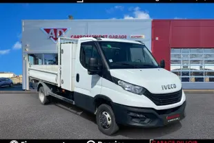 Vue 3/4 avant droit d'un utilitaire Iveco Daily 3.0 blanc avec benne coffre, stationné devant un garage.
