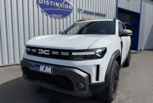 Vue 3/4 avant droite du Dacia Duster Hybrid 155 Extreme blanc glacier avec détails noirs et rétroviseur bronze.