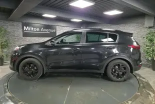 Vue de profil côté gauche d'un KIA Sportage noir Black Edition 2021 avec jantes alliage noires et toit panoramique.