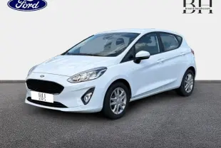 Ford Fiesta blanc glacier vue 3/4 avant droit, avec calandre noire et jantes argentées.