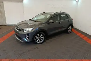 KIA Stonic gris foncé vue 3/4 avant droit dans un garage avec sol à damier noir et rouge.