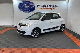 Renault Twingo Equilibre blanc vue 3/4 avant droit en intérieur, avec jantes spécifiques et rétroviseurs noirs.